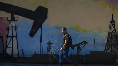 Un hombre pasa ante un mural en Caracas, Venezuela