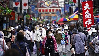 A street is crowded by shoppers in Tokyo