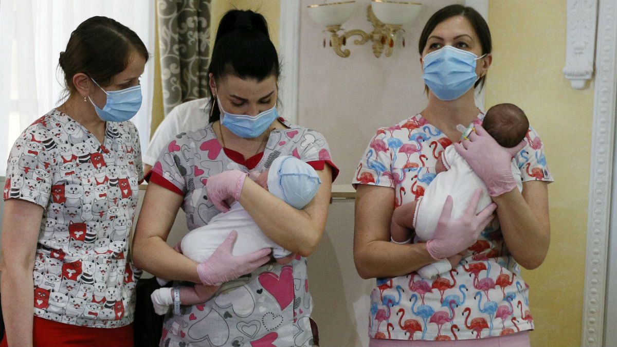 Nurses hold babies born from Ukrainian surrogate mothers prior to them meeting their parents, in Kyiv, Ukraine, Wednesday, June 10, 2020. 