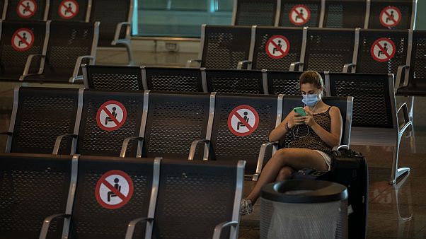 A passenger sits at Barcelona airport in Barcelona, Spain A passenger sits at Barcelona airport in Barcelona, Spain