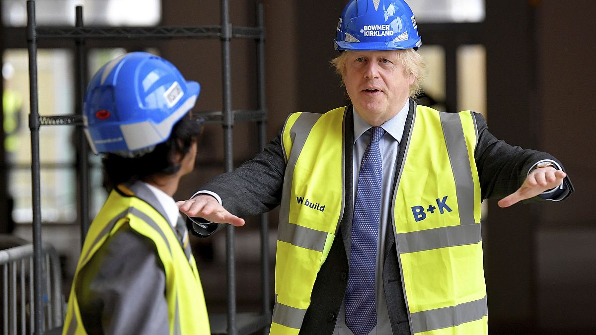 Britain's Prime Minister Boris Johnson talks with year 10 pupil Vedant Jitesh during a visit to the construction site of Ealing Fields High School in London, June 29, 2020.