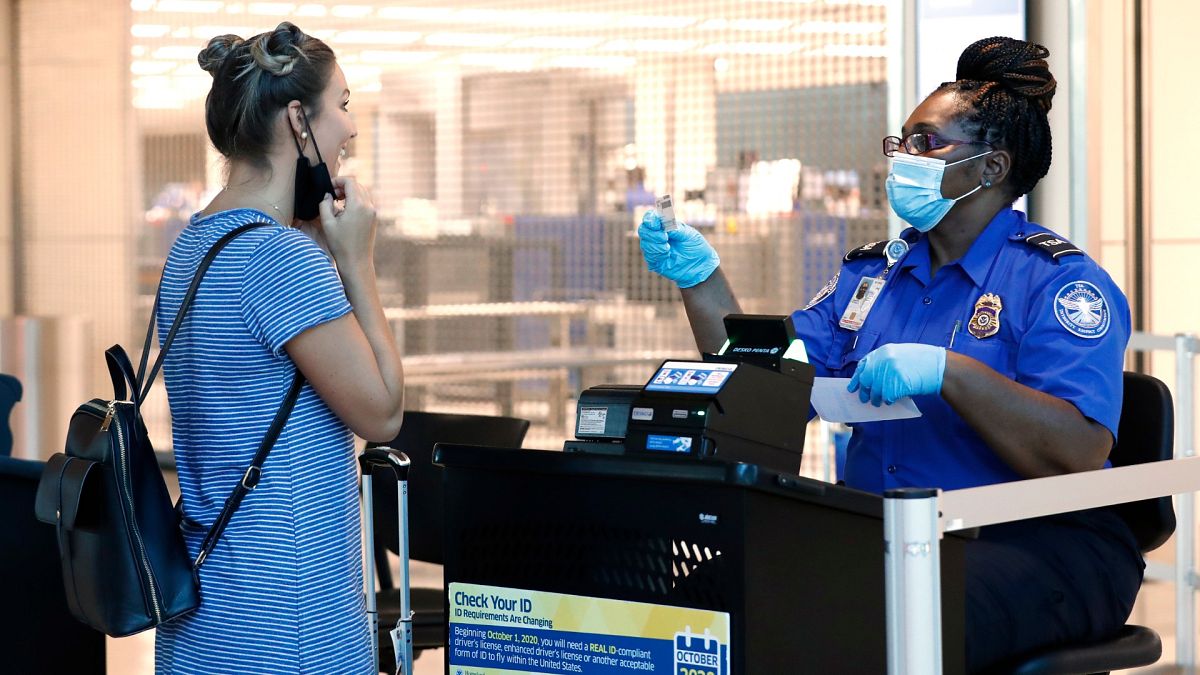L'agent de la TSA Patrisa Johnson, à droite, aide un voyageur à passer la sécurité avant de s'envoler de Love Field à Dallas, le mercredi 24 juin 2020.