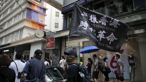 Demonstrant mit Flagge, auf der zur Befreiung Hongkongs aufgerufen wird Demonstrant mit Flagge, auf der zur Befreiung Hongkongs aufgerufen wird