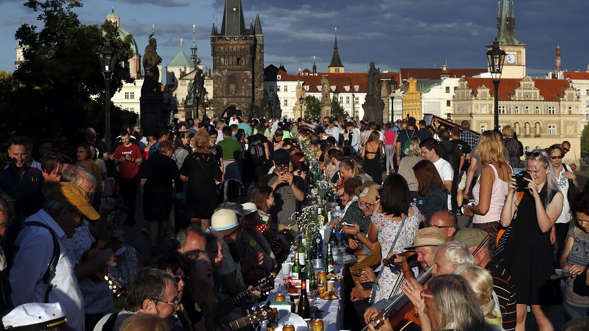Residents sit to dine on a 500 meter long table set on the medieval Charles Bridge  in Prague, Czech Republic, Tuesday, June 30, 2020. 