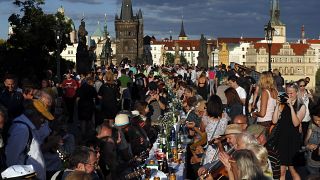 Residents sit to dine on a 500 meter long table set on the medieval Charles Bridge  in Prague, Czech Republic, Tuesday, June 30, 2020. 