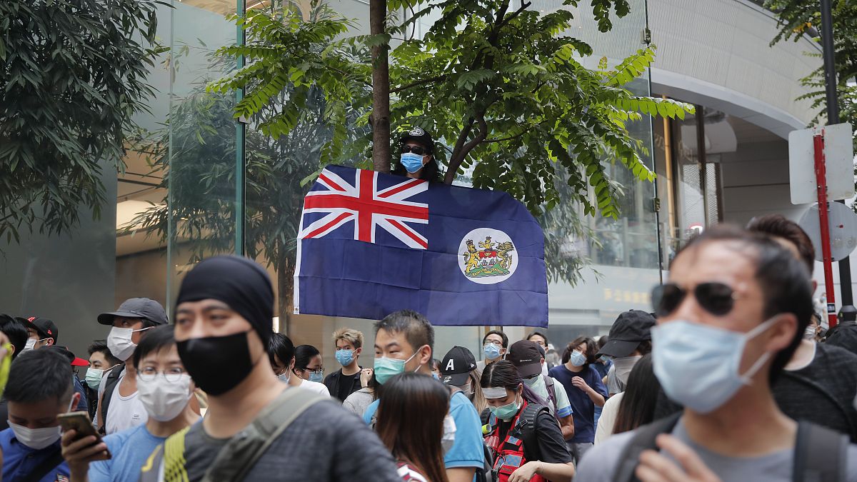 A man displays the Hong Kong colonial flag on the anniversary of Hong Kong's handover to China from Britain in Hong Kong, Wednesday, July. 1, 2020.