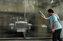 A window cleaner works on a window at a Rolls-Royce showroom in London