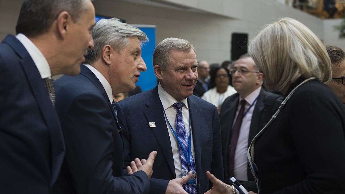 Yakiv Smolii, governor of Ukraine's central bank (C), greets attendees during the IMF/World Bank spring meeting in Washington, DC on April 21, 2018. 