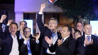 Croatia's Prime Minister incumbent Andrej Plenkovic (holding a Croatian flag) celebrates victory at the Archaeological Museum in Zagreb, on July 5. 2020.
