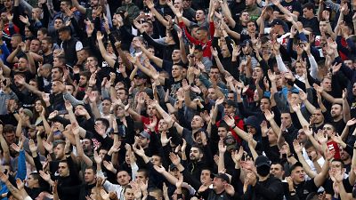 In this Wednesday, June 10, 2020. photo, Red Star fans support their team during a Serbian National Cup semi final soccer match between Partizan and Red Star in Belgrade.