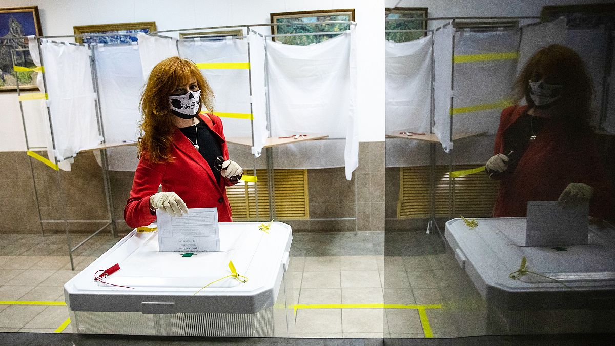 A voter wearing a face mask casts her ballot in Moscow, Russia. Russians vote on a constitutional reform that would allow President Vladimir Putin to stay in power until 2036