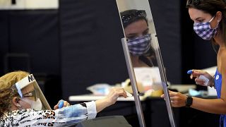 Harris County election clerk Nora Martinez, left, helps a voter, Monday, June 29, 2020, in Houston. Early voting for the Texas primary runoffs began Monday. 