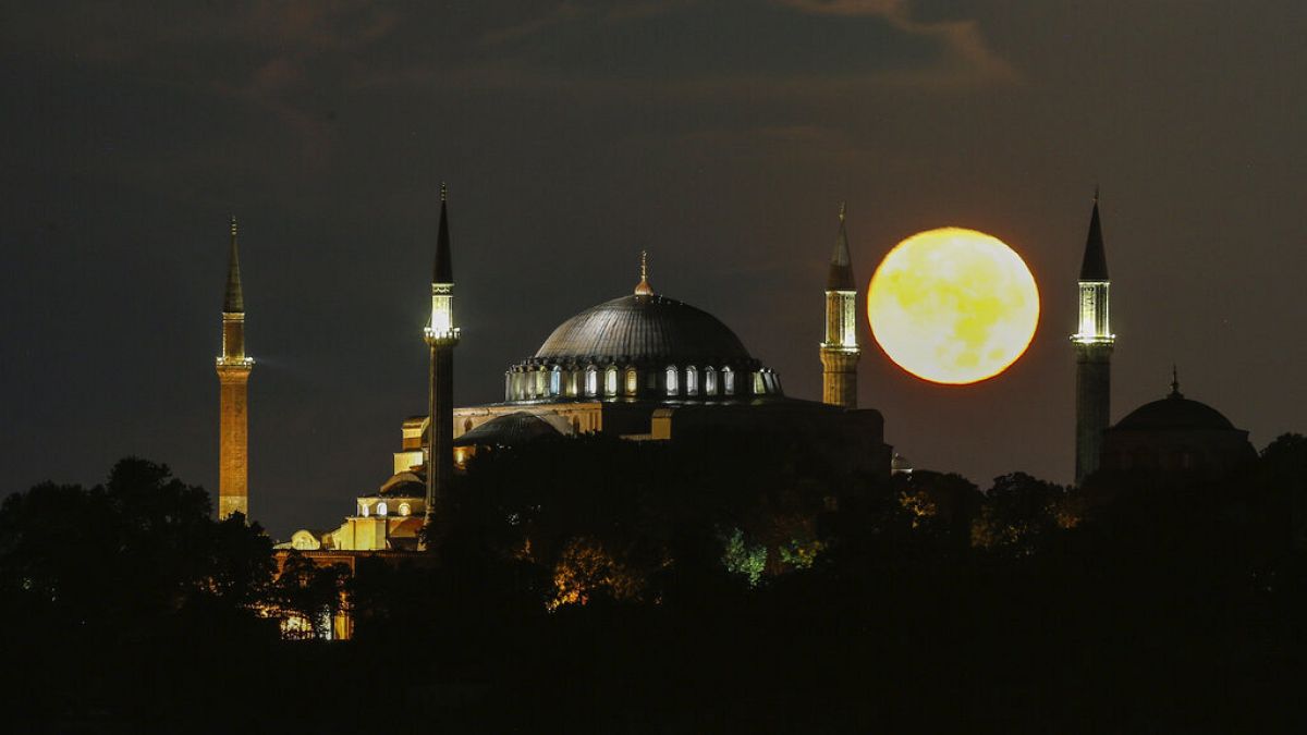 The full moon rises behind the Byzantine-era Hagia Sophi