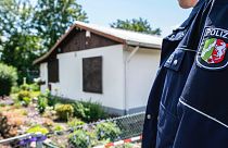 Rendőr áll egy ház közelében egy pedofilhálózat elleni nyomozás során a németországi Münsterben.