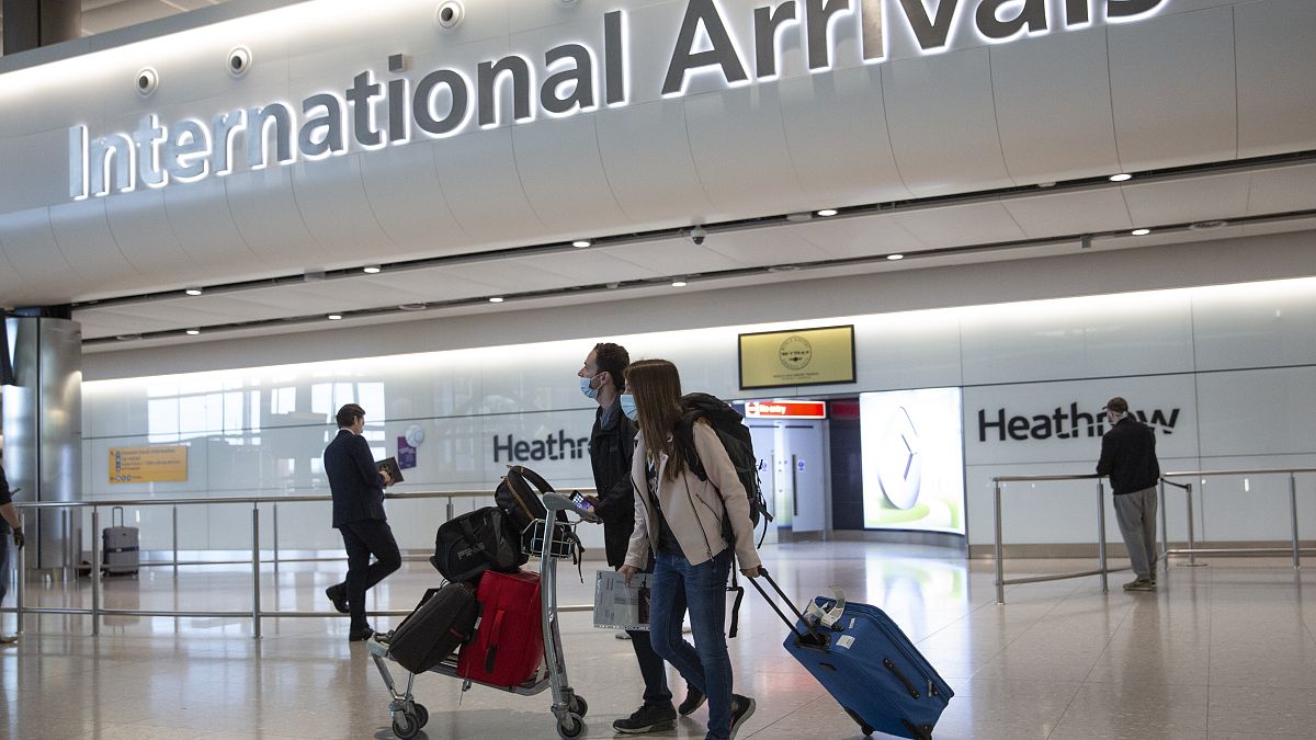 Passengers wearing face masks arrive at London's Heathrow Airport on June 8, 2020.