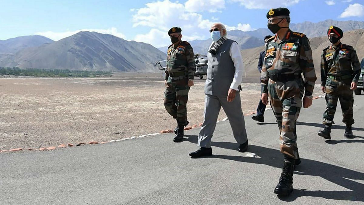 In this handout photo provided by the Press Information Bureau, Indian Prime Minister Narendra Modi walks with soldiers during a visit to the Ladakh area, India, Friday, July 