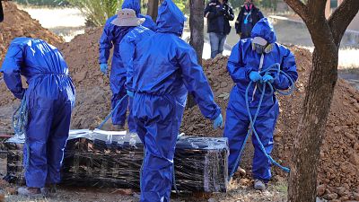 Trabajadores se preparan para enterrar a un fallecido por COVID-19 en Cochabamba