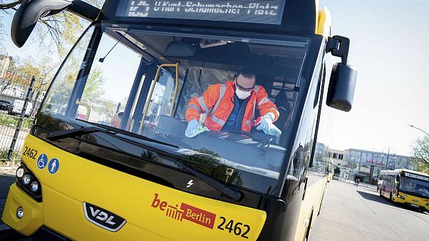 An employee wearing mouth and nose protection and protective gloves cleans the passenger area of a BVG bus at the terminal in Berlin, Germany, Wednesday, April 22, 2020. An employee wearing mouth and nose protection and protective gloves cleans the passenger area of a BVG bus at the terminal in Berlin, Germany, Wednesday, April 22, 2020.