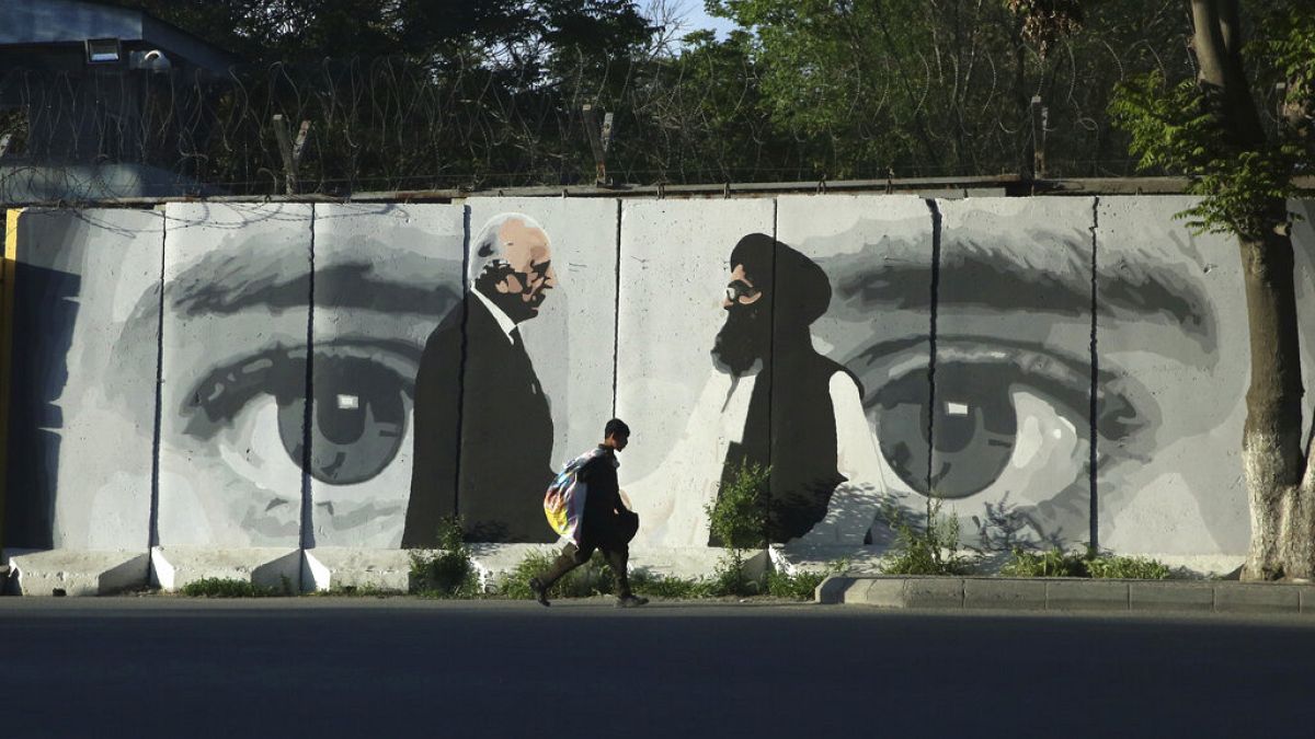 Az amerikai Zalmay Khalilzad és Mullah Abdul Ghani Baradar tálib tárgyaló képe egy kabuli falon