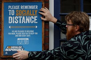 A pub owner put signs in place instructing on social distancing at the Chandos Arms pub in London, Wednesday, July 1, 2020.