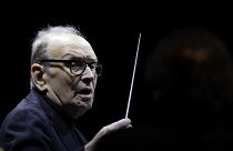 In this file photo dated Tuesday, March 6, 2018, Italian composer Ennio Morricone directs an ensemble during a concert of his "60 Year Of Music World Tour", in Milan, Italy