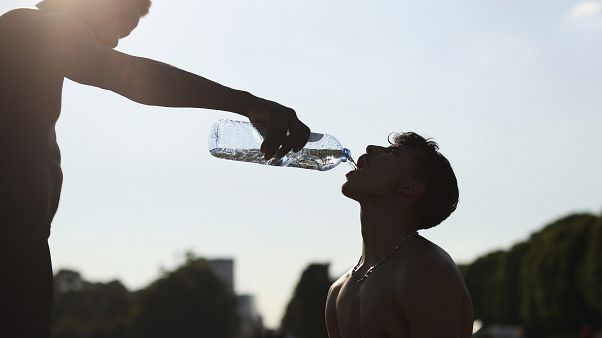 Un entrenador da agua a su estudiante durante una sesión de entrenamiento en un caluroso día de verano en Bruselas el 25 de junio de 2020. Un entrenador da agua a su estudiante durante una sesión de entrenamiento en un caluroso día de verano en Bruselas el 25 de junio de 2020.