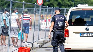 A police officer walks next to apartment buildings that are partly under quarantin due to a new coronavirus outbreak in Verl, Germany, Wednesday, June 24, 2020.