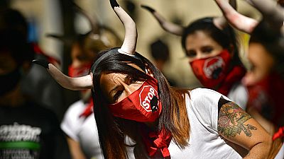 Demonstrators wear faces masks while protesting against San Fermin's bullfighting, canceled this year by the conoravirus pandemic, in Pamplona, northern Spain, Tuesday, July 7