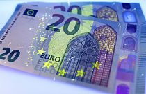 Two new 20 Euro bank notes are photographed under black light in Frankfurt, Germany
