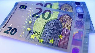 Two new 20 Euro bank notes are photographed under black light in Frankfurt, Germany