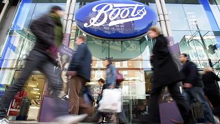 FILE - In this Oct. 5, 2005 file photo, people walk past a Boots pharmacy in central London.