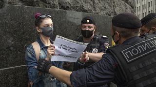 A journalist from the RT television channel holds a poster reading "Journalists are not criminals! We are Ivan Safonov" during a protest outside the FSB headquarters in Moscow
