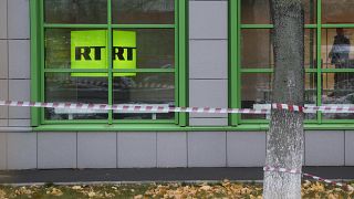 Russian state-owned television station RT logo is seen at the window of the company's office in Moscow.