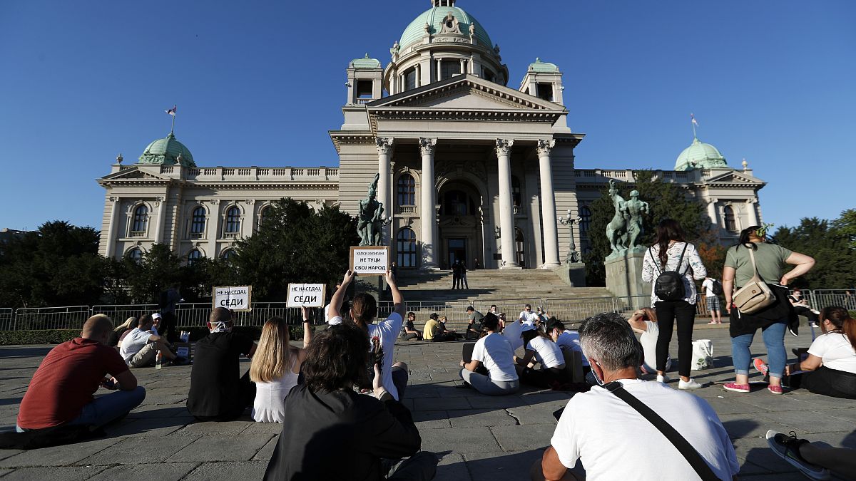 People sit during a protest in front Serbian Parliament building in Belgrade, Serbia,Thursday, July 9, 2020.