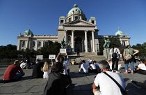 People sit during a protest in front Serbian Parliament building in Belgrade, Serbia,Thursday, July 9, 2020.