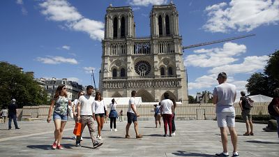 People walk on the forecourt of Notre Dame's Cathedral, in Paris, Sunday, May 31, 2020.