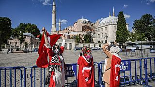 Ciudadanos envueltos en la bandera turca celebran la conversión de la basílica de Santa Sofía en mezquita