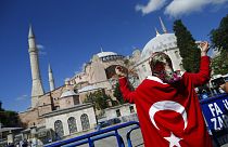 People, draped in Turkish flags, chant slogans, outside the Byzantine-era Hagia Sophia