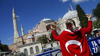 People, draped in Turkish flags, chant slogans, outside the Byzantine-era Hagia Sophia