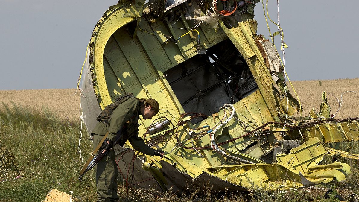 In this July 22, 2014 file photo, a pro-Russian rebel touches the MH17 wreckage at the crash site of Malaysia Airlines Flight 17, near the village of Hrabove, eastern Ukraine.