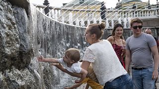 Ребенок играет с фонтаном в центре Москвы.