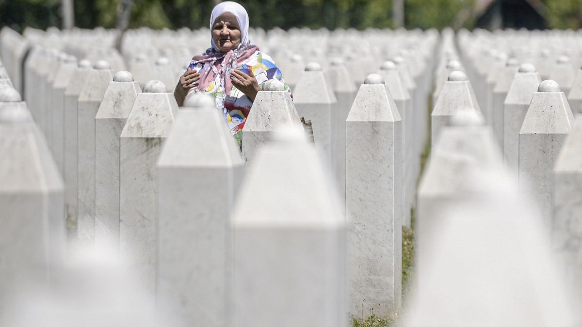 A woman prays at the memorial cemetery in Potocari, near Srebrenica, Bosnia.