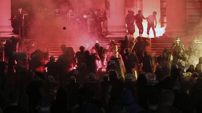 Protesters clash with riot police on the steps of the Serbian parliament during a protest in Belgrade, Serbia, Friday, July 10 2020. 