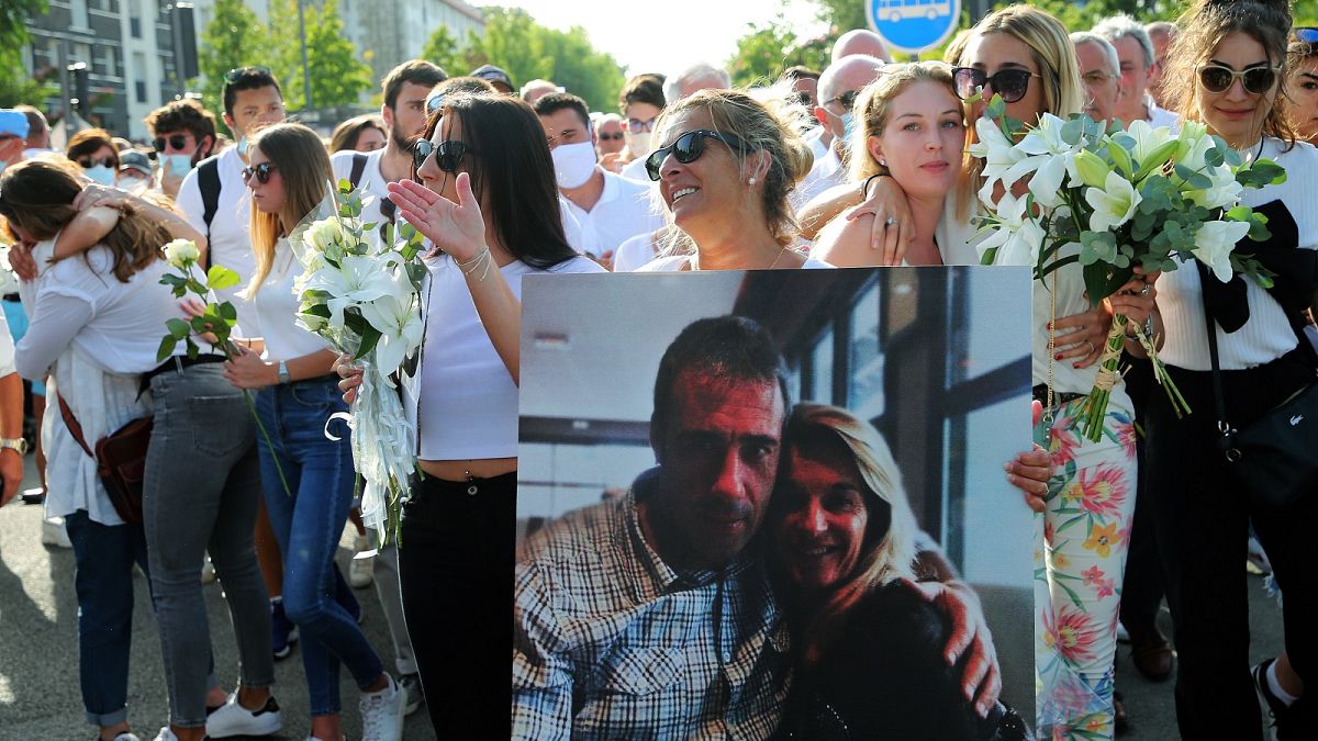 Veronique Monguillot holds a photo of her with her husband during a protest march in Bayonne