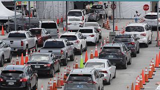 Vehicles wait in line at a drive-thru COVID-19 testing site outside Hard Rock Stadium in Miami Gardens, Florida