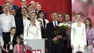 Incumbent President Andrzej Duda, center, his wife Agata Kornhauser-Duda, left, and daughter Kinga, right, sing along with supporters in Pultusk, Poland, Sunday, July 12, 2020