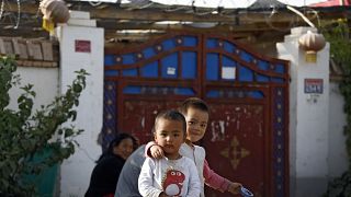 Doğu Türkistan'ın Hoten kentinde evlerinin önünde oynayan Uygur çocuklar 