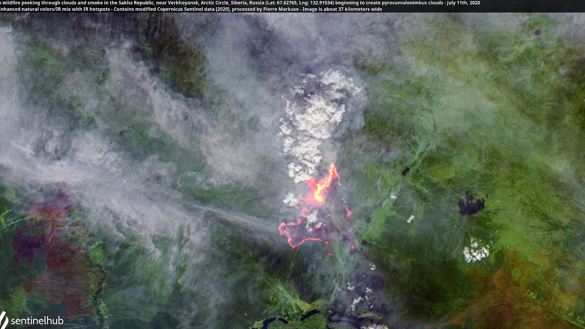 A wildfire peeking through clouds and smoke in the Sakha Republic, near Verkhoyansk, Arctic Circle