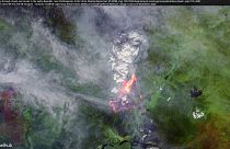 A wildfire peeking through clouds and smoke in the Sakha Republic, near Verkhoyansk, Arctic Circle