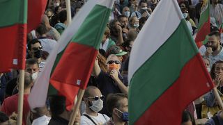 A protester seen behind flags whistles during anti-governmental protest in downtown Sofia on Monday, July 13, 2020.